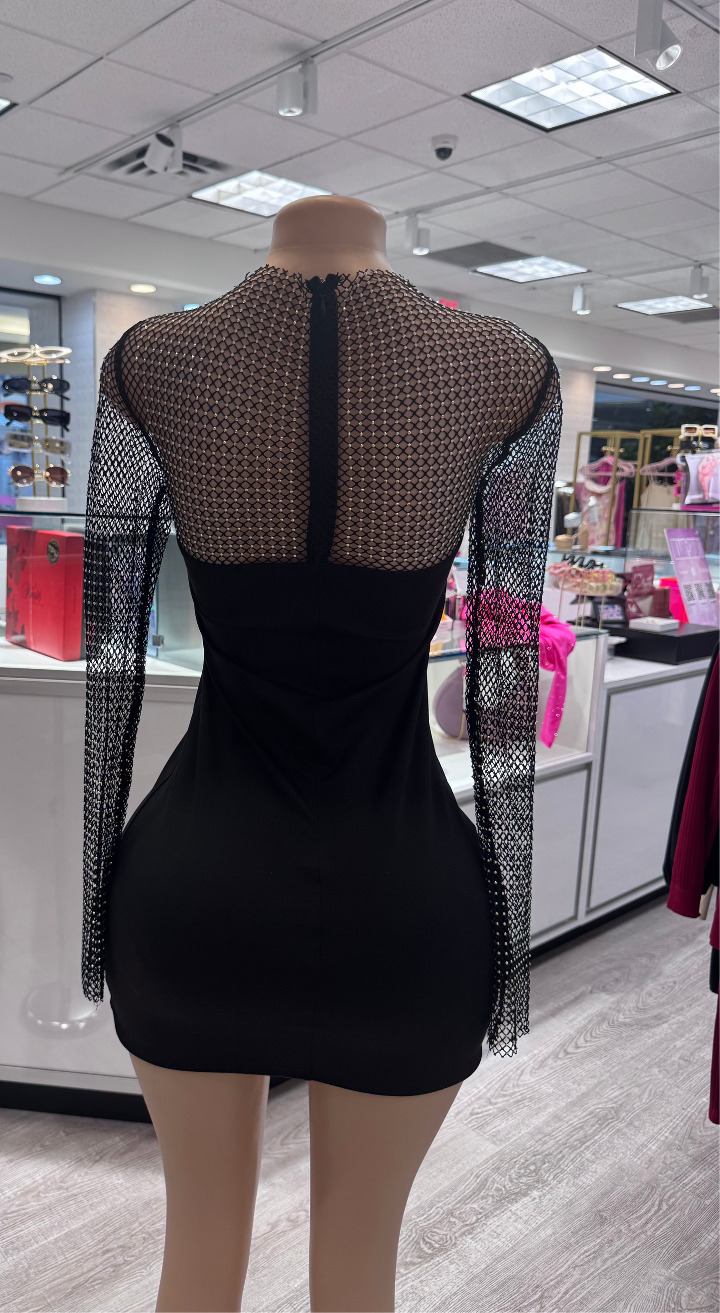 Back view of the sophisticated Laura Mesh Diamond Sleeve Mini Long Sleeve Dress displayed on a mannequin. The dress highlights a seamless back zipper and exquisite mesh diamond detailing, ideal for special occasions.