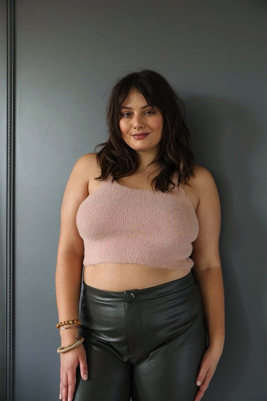 a woman wearing black leather pants and a pink crop top