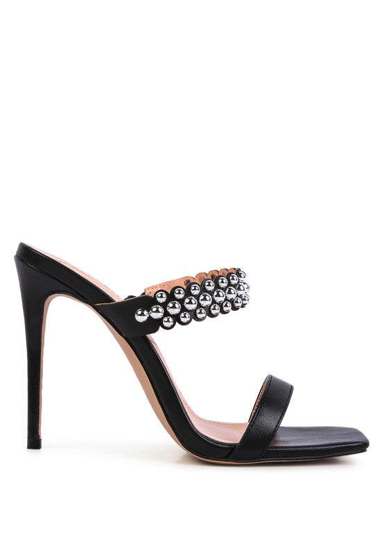 a black high heeled sandal with a jewel embellishment