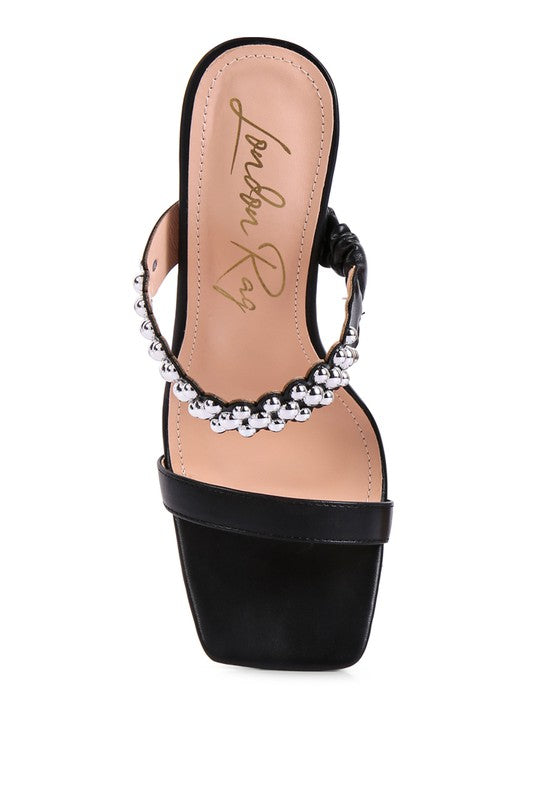 a black high heeled sandal with a beaded ankle strap