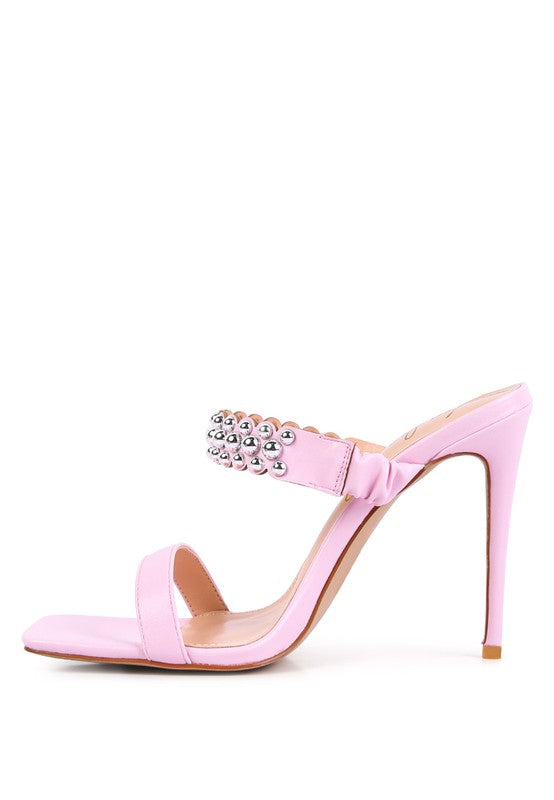 a pink high heeled sandal with a jewel embellishment