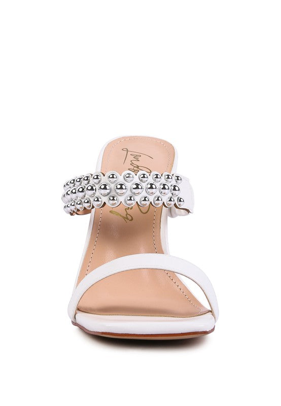 a women's white high heeled sandal with a jewel embellishment