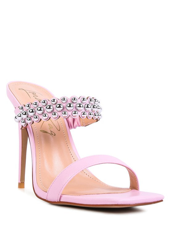 a pink high heeled sandal with a jewel embellishment