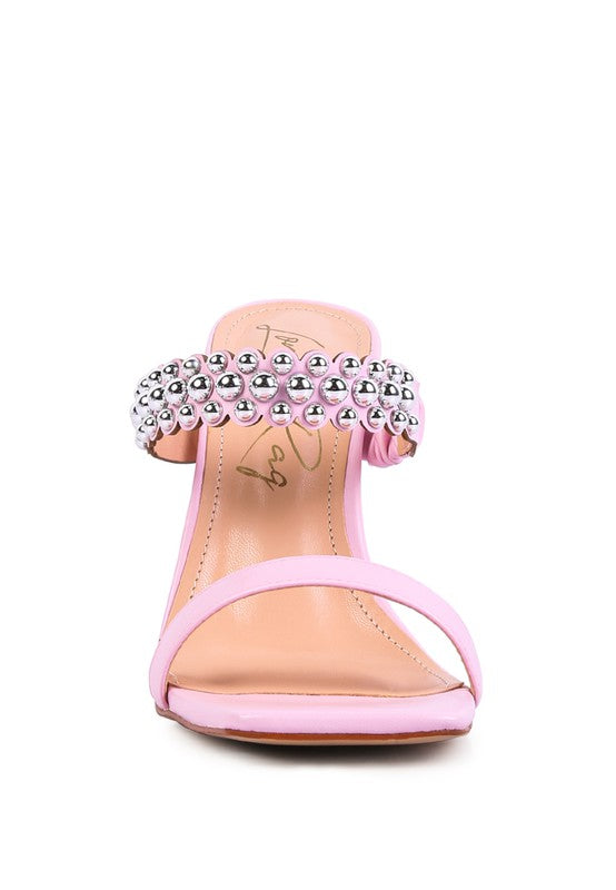 a pink high heeled sandal with a jewel embellishment