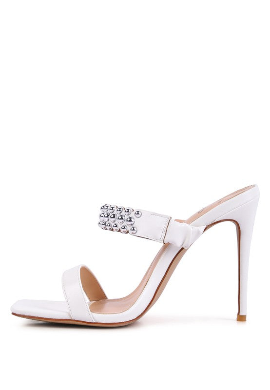 a women's white high heeled sandal with a crystal embellishment