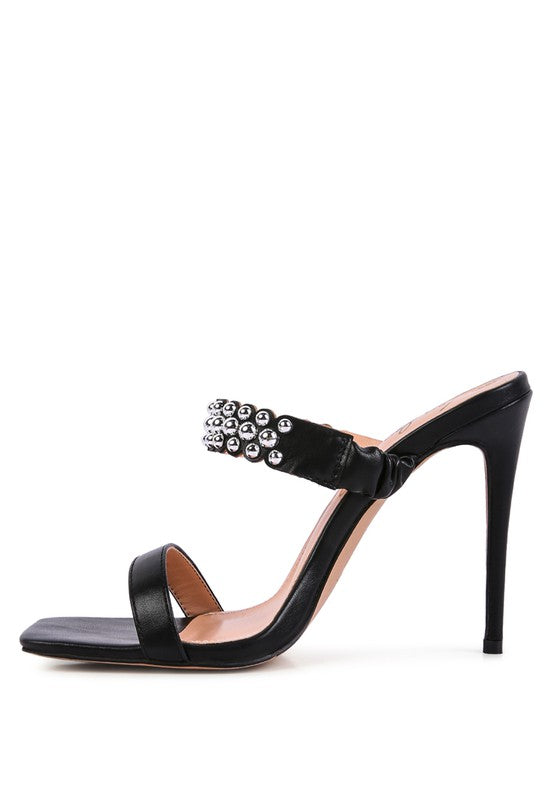 a black high heeled sandal with a jewel embellishment