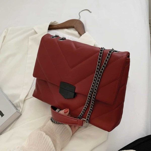 a woman is holding a red handbag