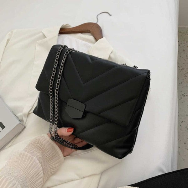 a woman's hand holding a black purse