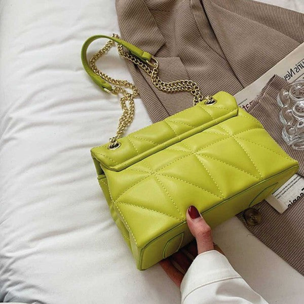 a woman's hand holding a lime green purse