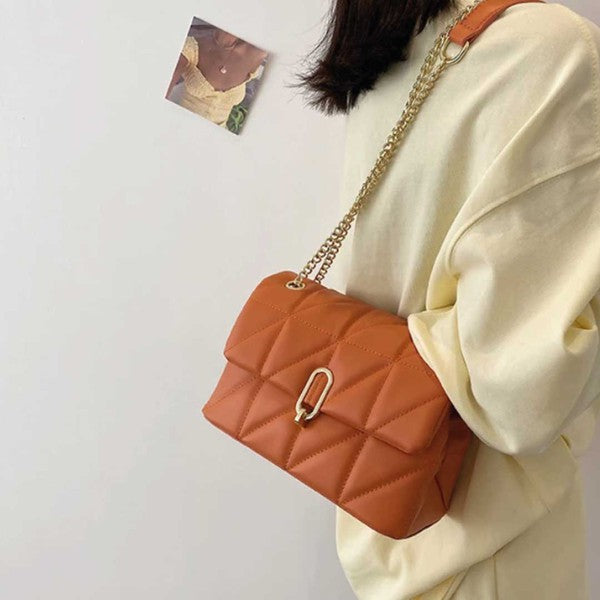 a woman wearing a white sweater holding a brown purse