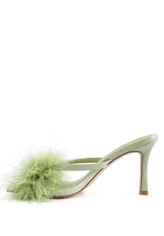 a pair of shoes with a green feather on the heel