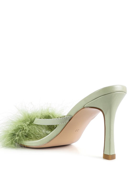 a pair of shoes with a green feather on the heel