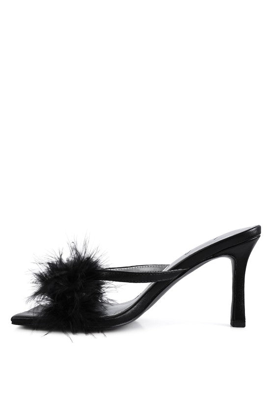 a pair of black shoes with a fur ball on the heel