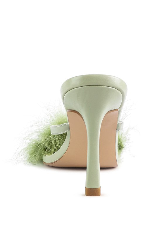 a pair of shoes with a green feather on the heel