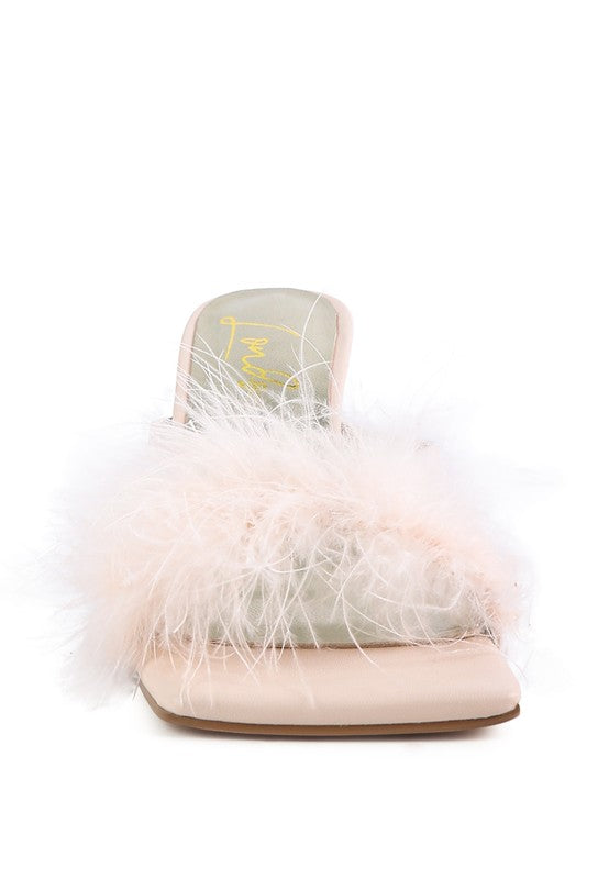 a women's slip on sandal with a fluffy white feather