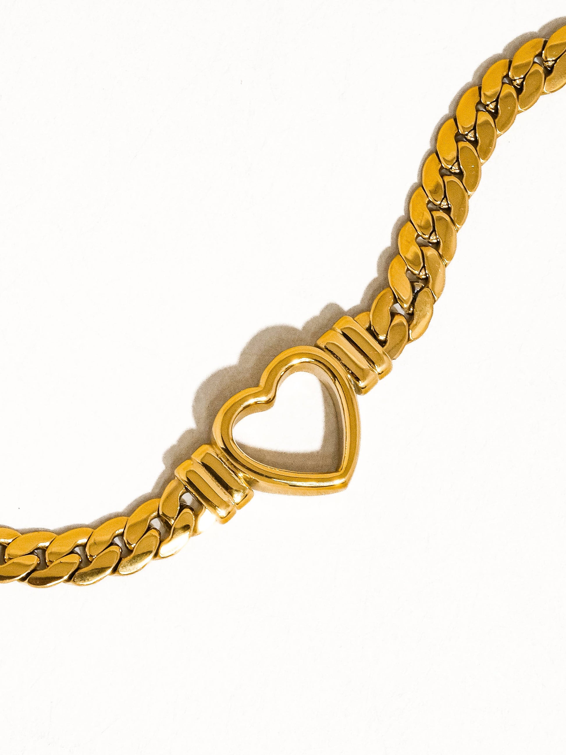 a gold bracelet with a heart on it