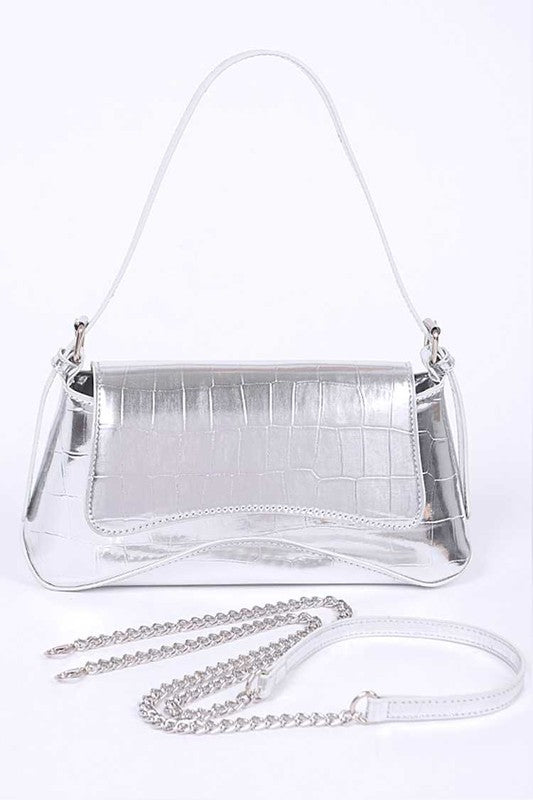 a silver purse sitting on top of a white table