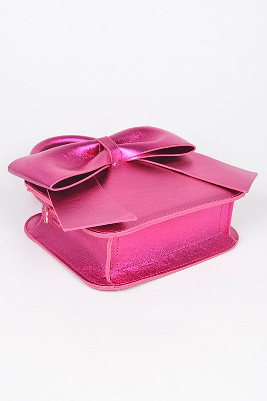 a pink purse with a bow on top of it