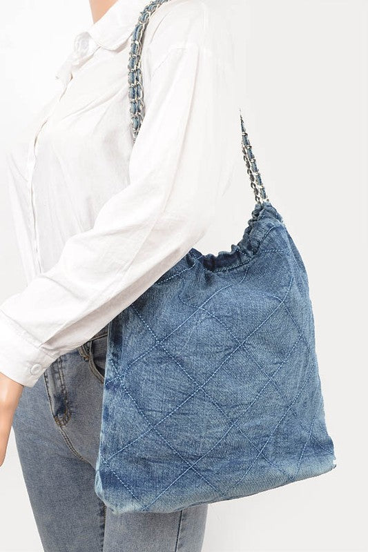 a woman is holding a denim bag in her hands