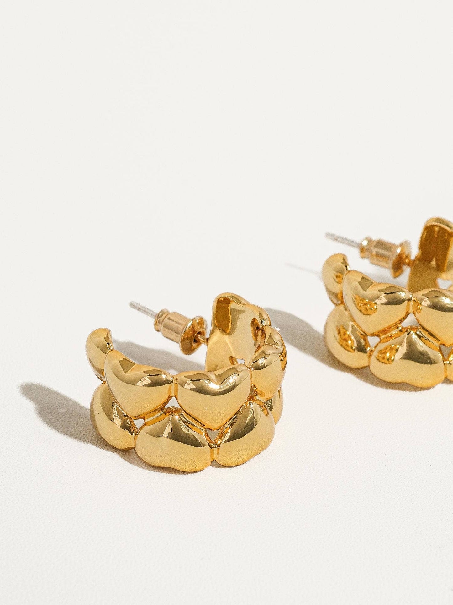 a pair of gold earrings on a white background