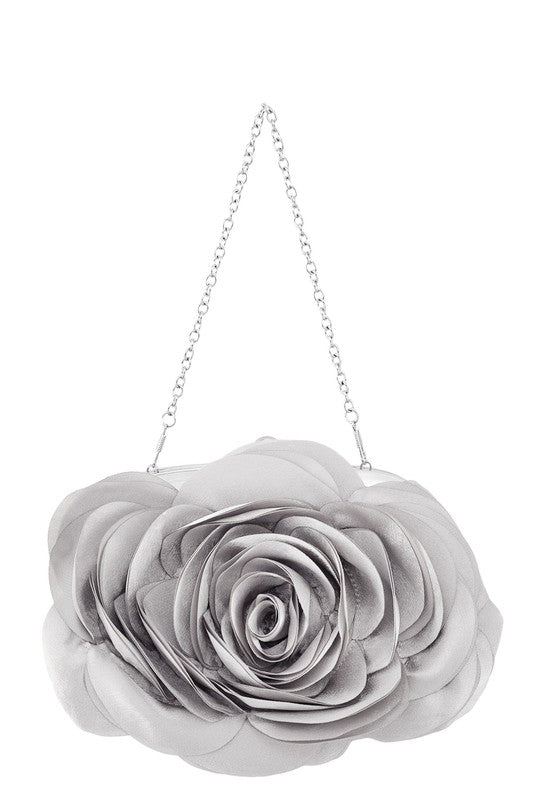 a flower hanging from a chain on a white wall