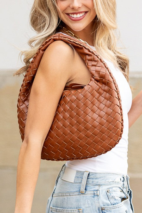 a beautiful blond woman holding a brown purse