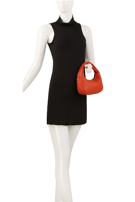 a mannequin wearing a black dress with a red purse