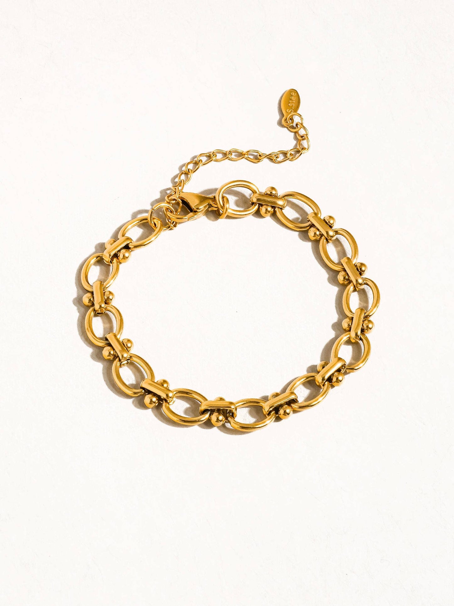 a gold bracelet on a white background