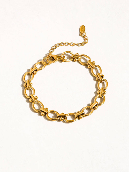 a gold bracelet on a white background