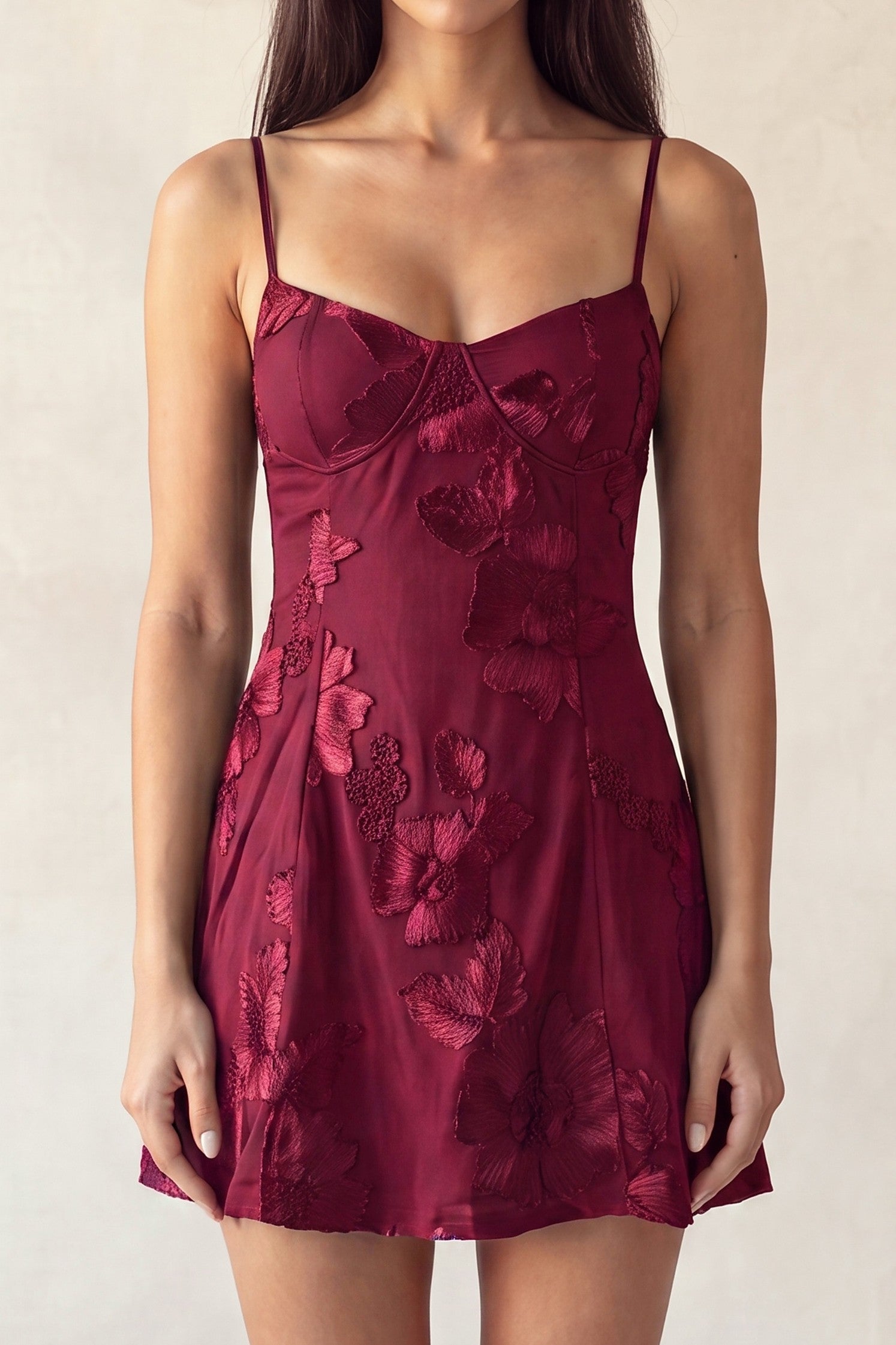 Burgundy floral-embroidered mini dress with thin straps, featuring a fitted bodice and flared skirt.