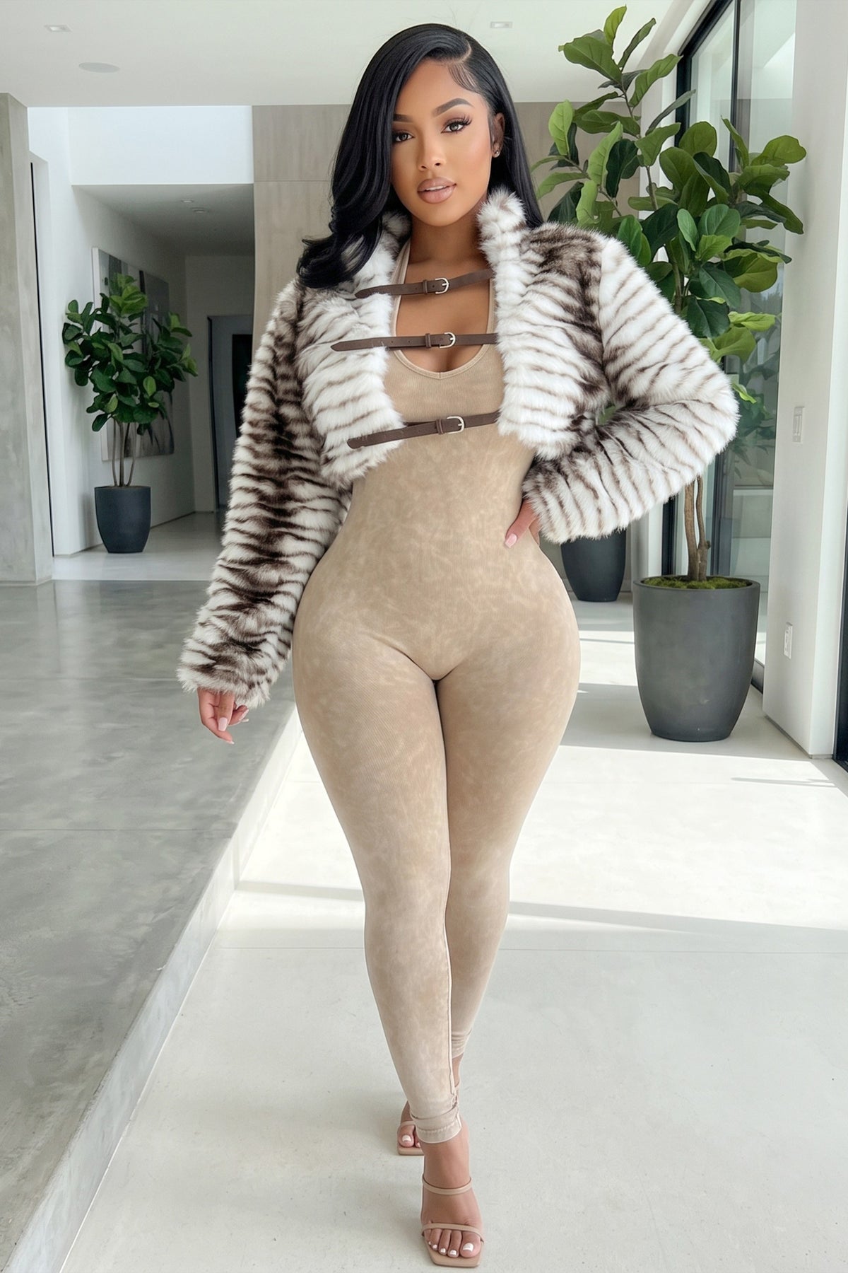 Model wearing Sorella cream and brown striped faux fur cropped jacket with oversized collar, long plush sleeves, and three brown buckle straps at Blaire Shops.
