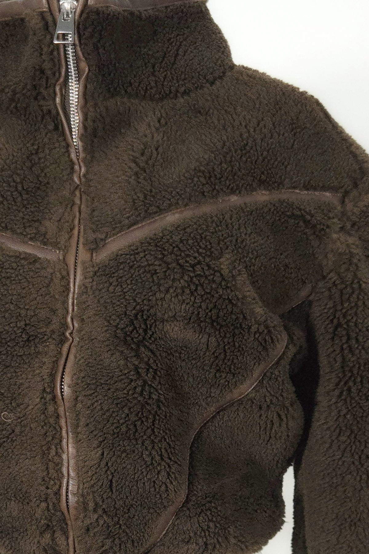 Blaire Shops model wearing a chocolate brown cropped teddy faux fur zip-up jacket with high collar, contrasting PU piping, and matching brown fleece pants.