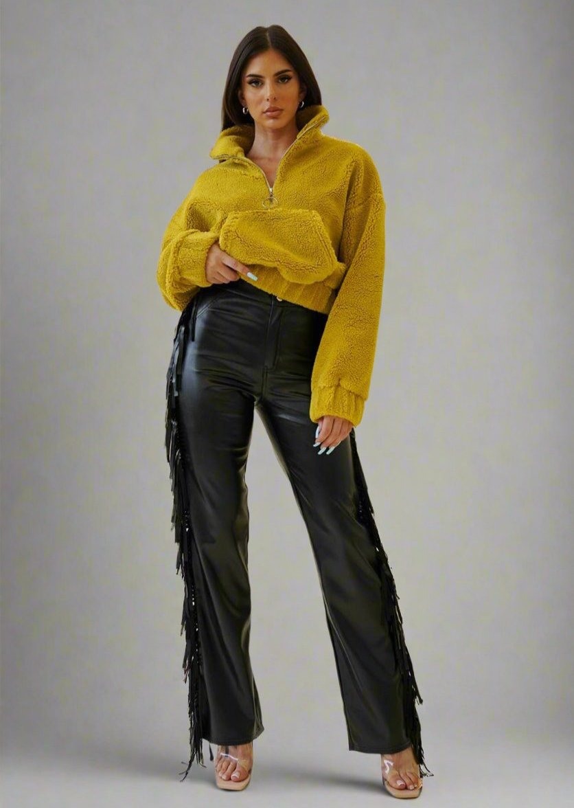 a woman in a yellow sweater and black pants