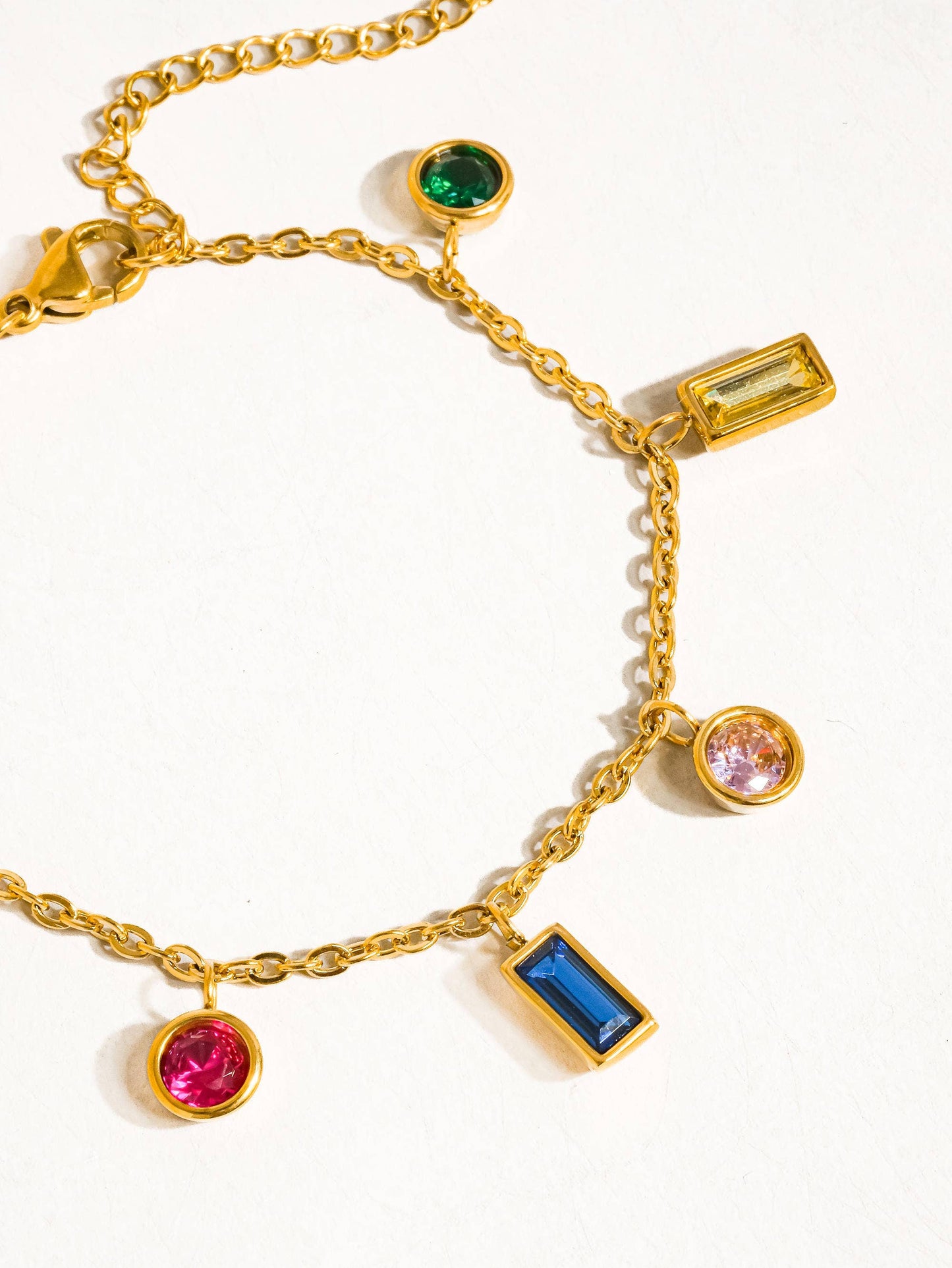 a gold bracelet with different colored stones on it