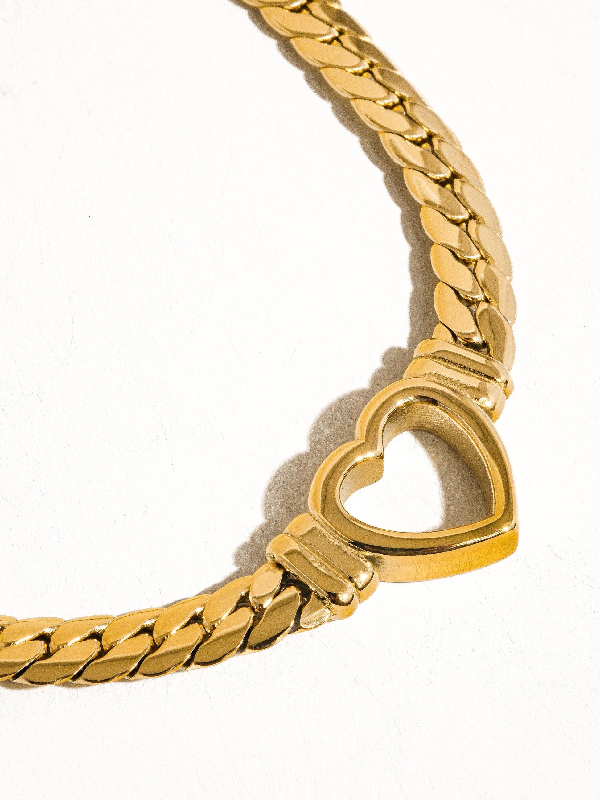 a gold bracelet with a heart shaped clasp