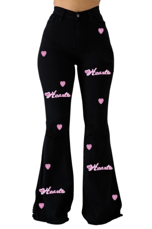 a woman wearing black pants with hearts on them