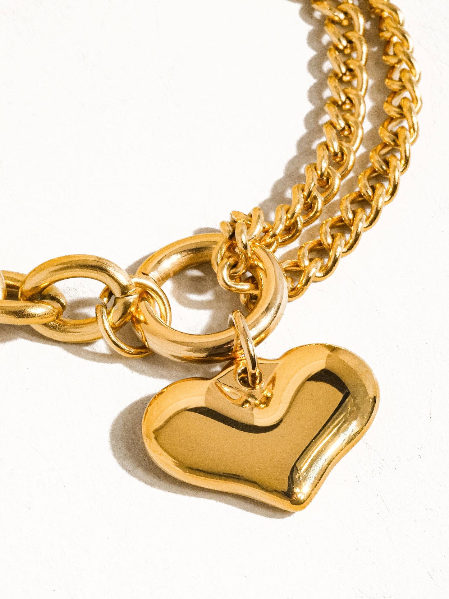 a gold heart charm on a gold chain