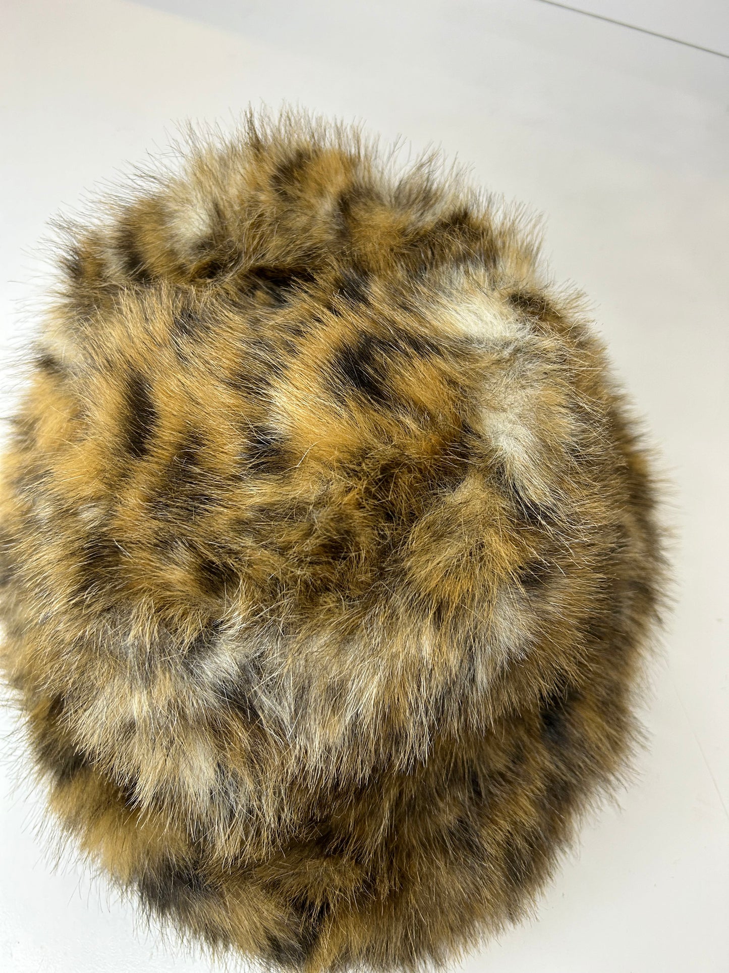 a brown and black fur ball on a white surface