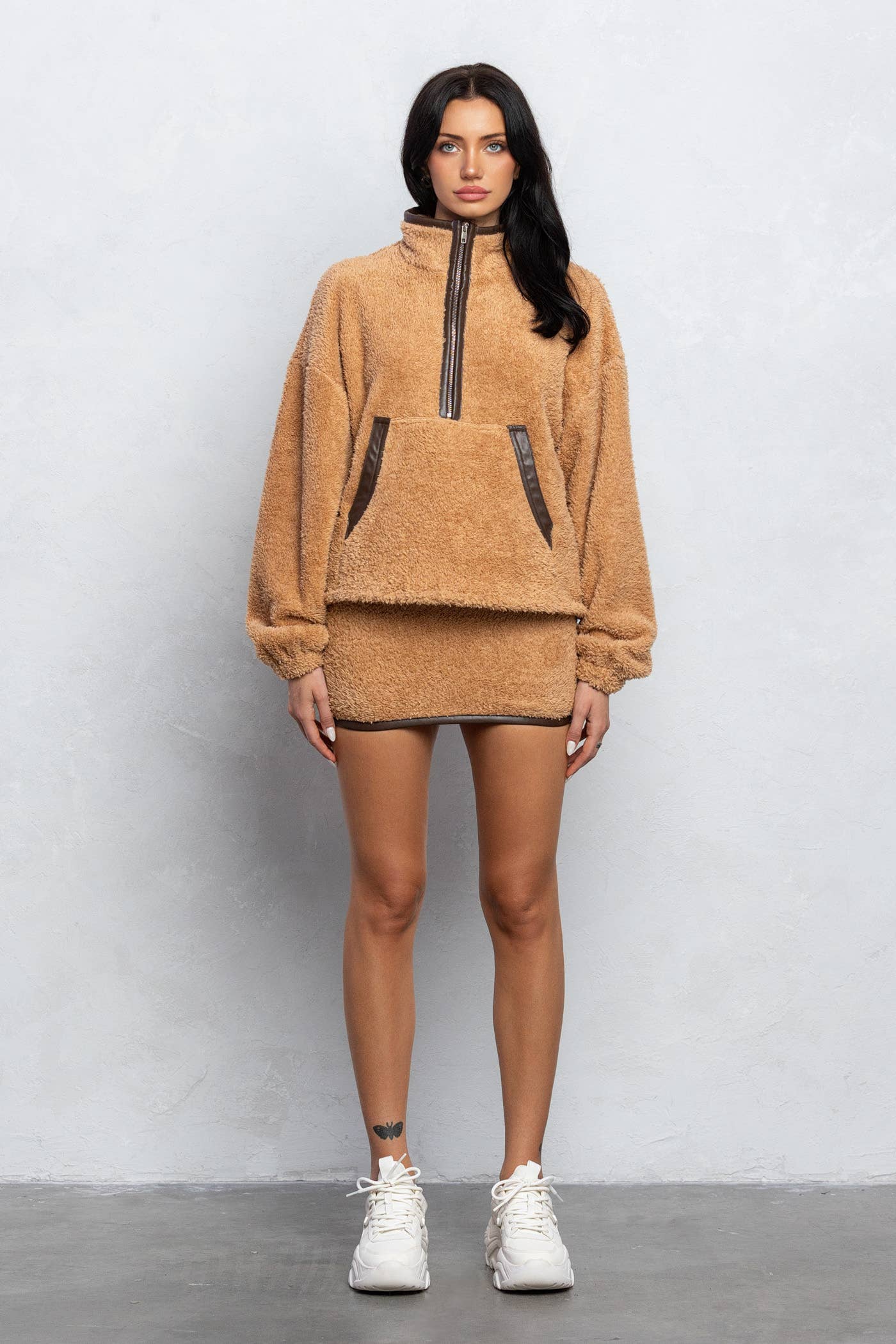 a woman in a brown sweater and shorts