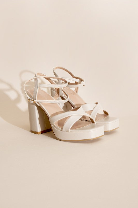 a pair of white high heeled sandals