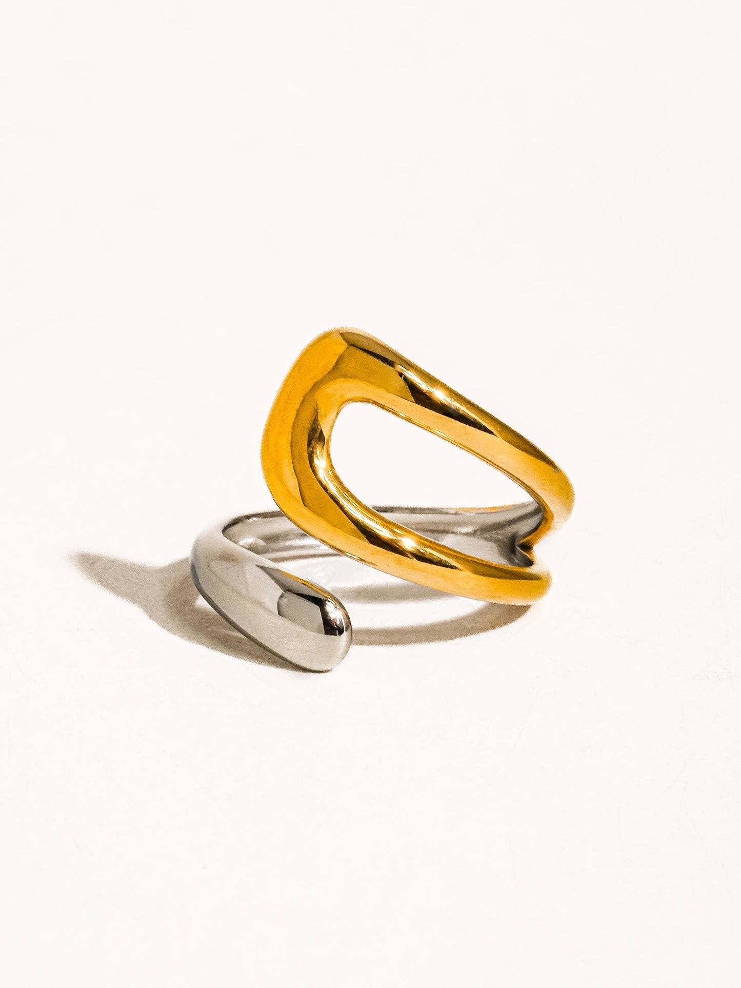 a yellow and silver ring sitting on top of a white surface