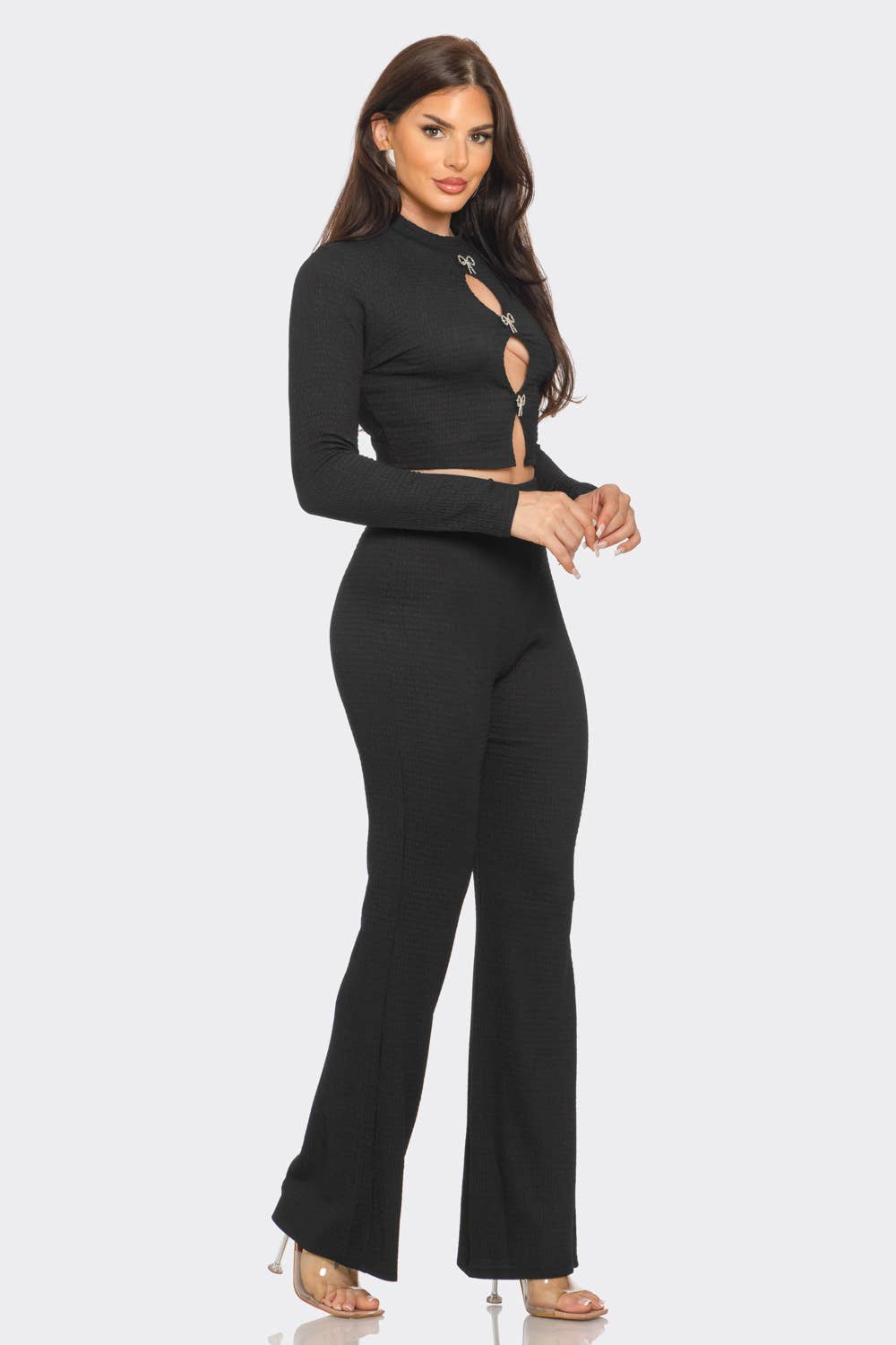 a woman wearing a black jumpsuit and heels