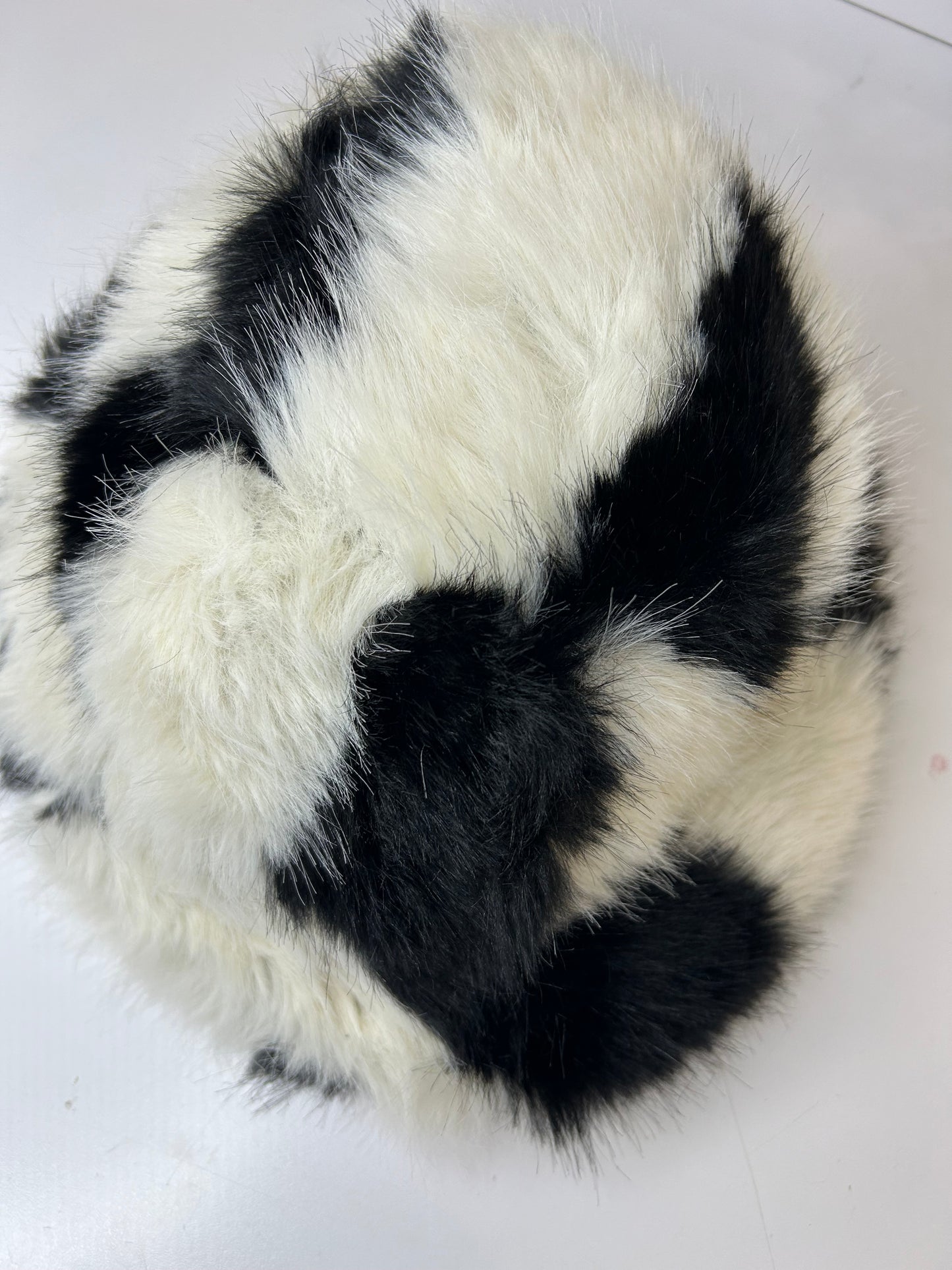 a black and white fur ball on a white surface