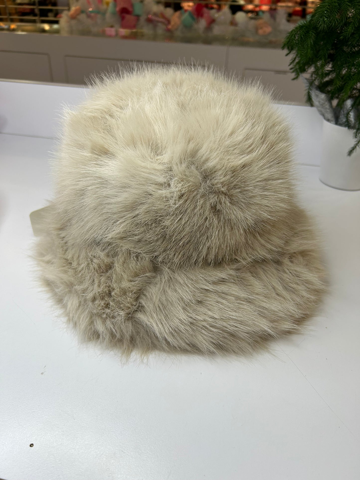 a white fur hat sitting on top of a table