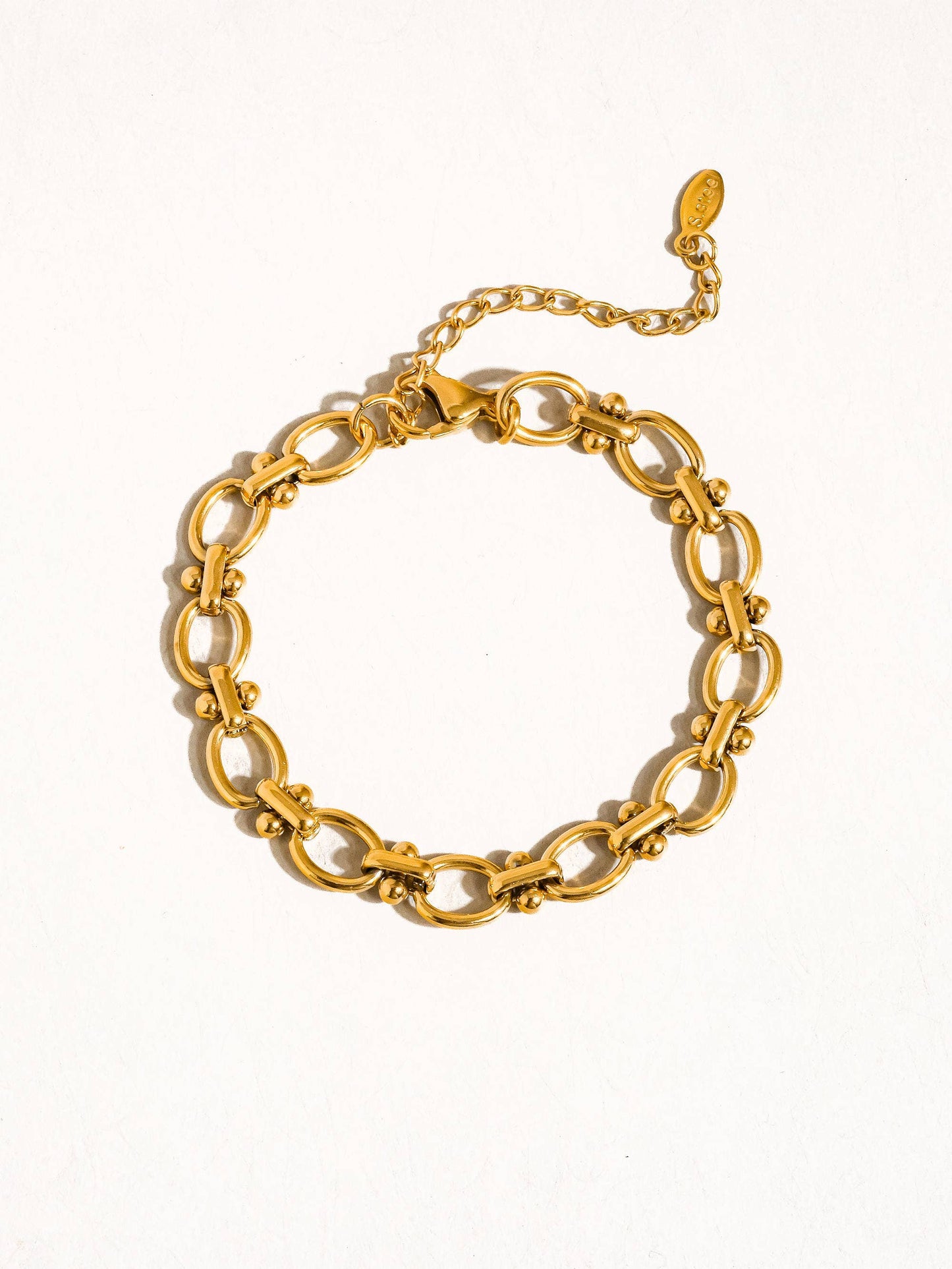 a gold chain bracelet on a white background