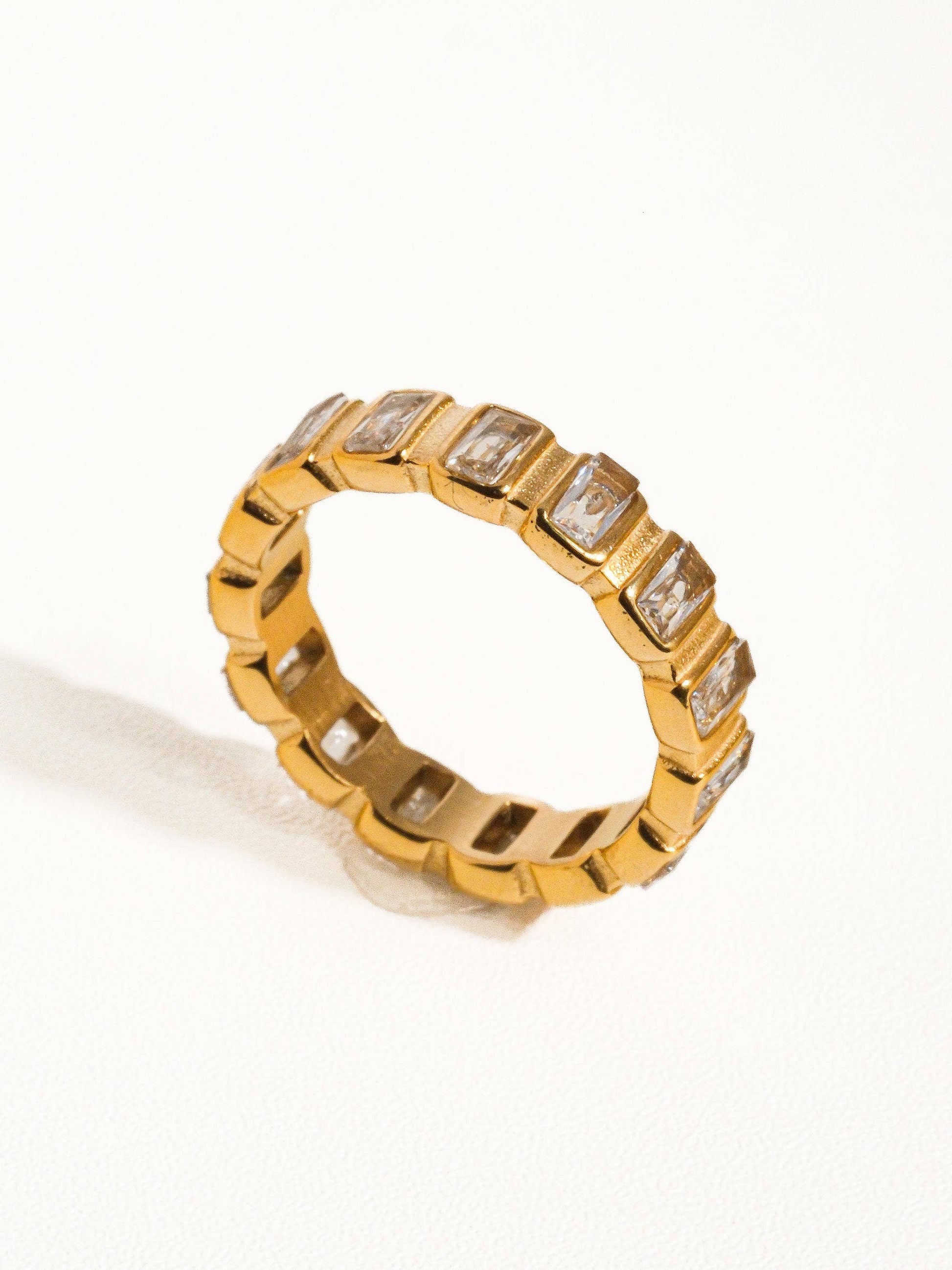 a gold ring with a row of baguettes