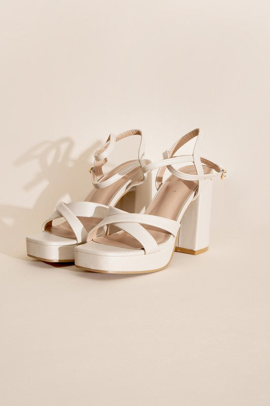 a pair of white high heeled sandals