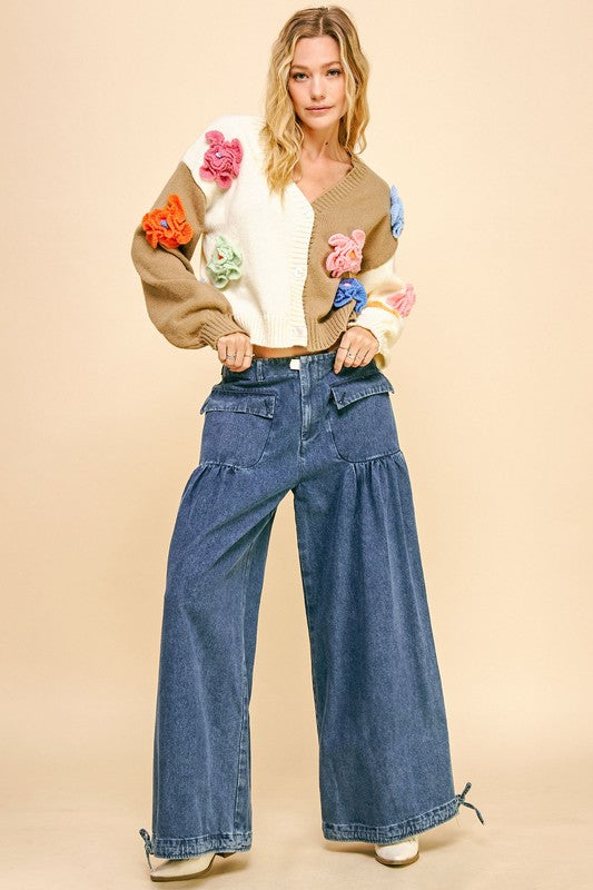 a woman in a sweater and jeans poses for a picture