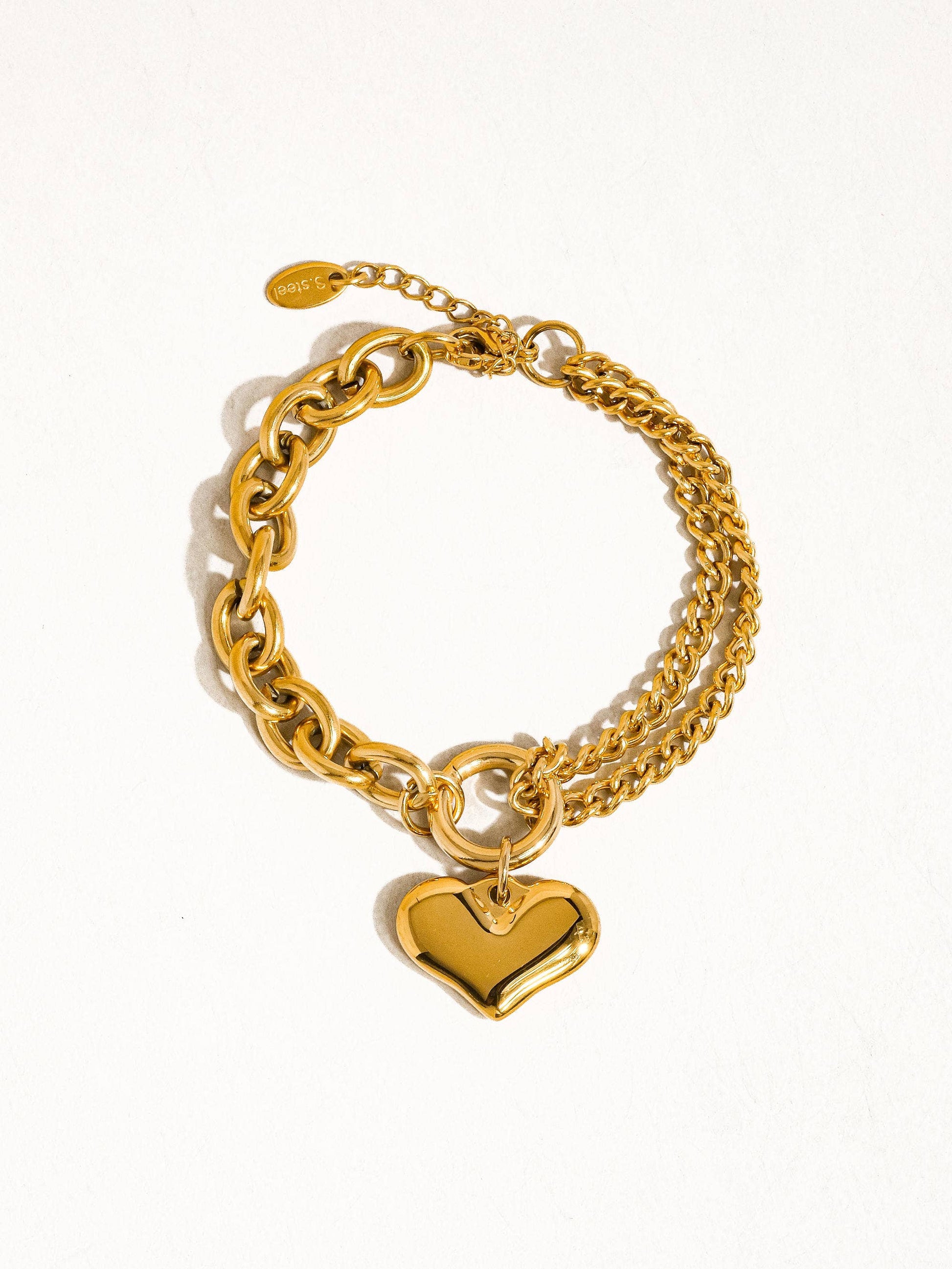 a gold bracelet with a heart charm