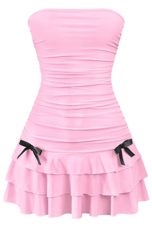 Cute pink babydoll dress with strapless design, ruched bodice, and playful black bow details on the sides, perfect for summer occasions.